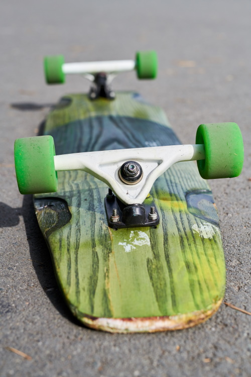 Close up of overturned longboard lying on concrete