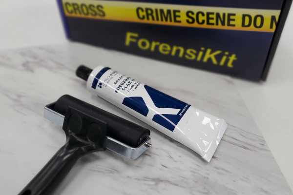 Ink roller and tube of ink on an inking surface with the ForensiKit product box in the background